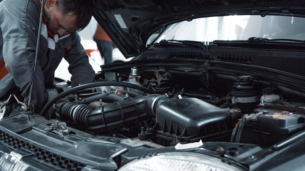 Mécanicien inspectant le moteur d'une voiture